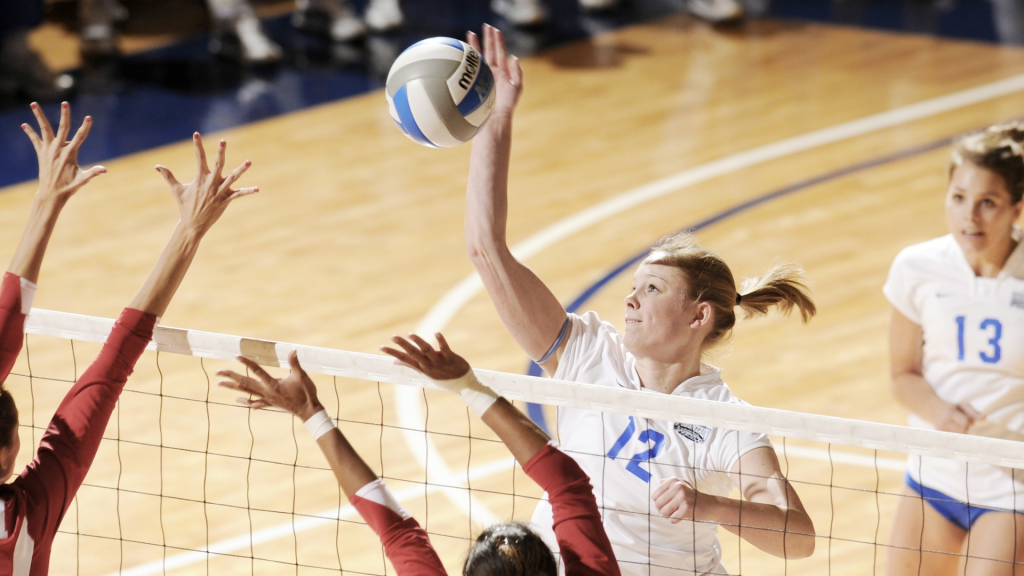 Joueuse de volley-ball effectuant un service au-dessus de la tête, geste répétitif pouvant provoquer une instabilité de l’épaule chez les sportifs.