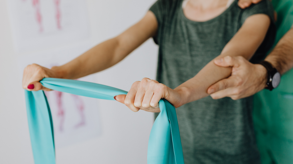 Kinésithérapeute montrant à un patient un exercice de renforcement de l’épaule pour traiter une tendinite
