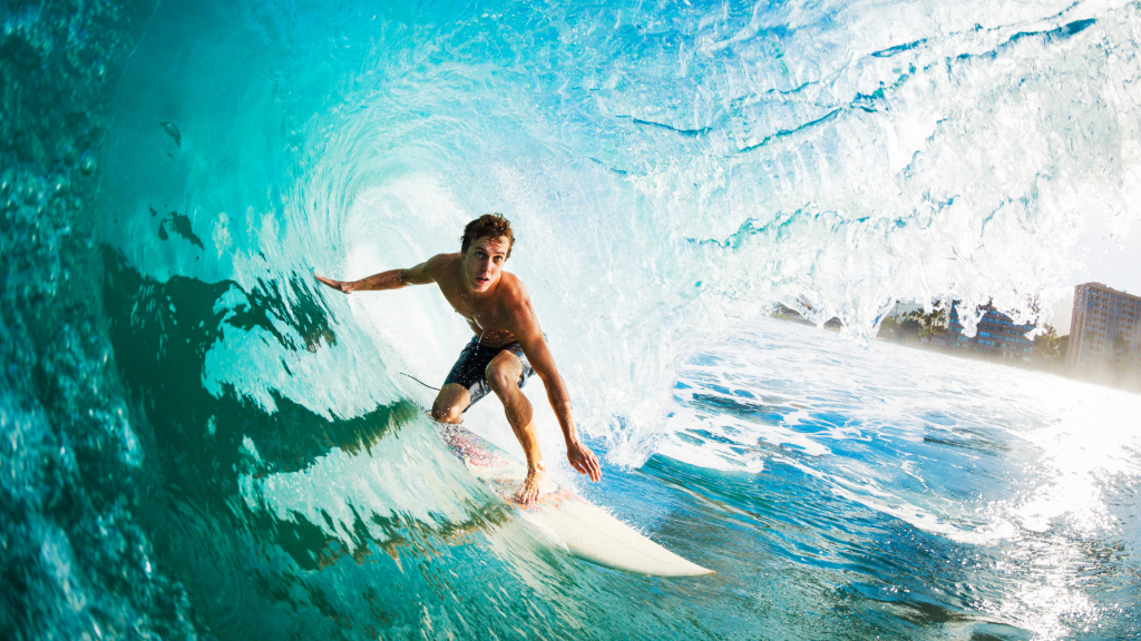 Surfeur dans un tube, épaules en extension et en rotation pour contrôler sa trajectoire, illustrant les contraintes sur l’épaule dans la pratique du surf.